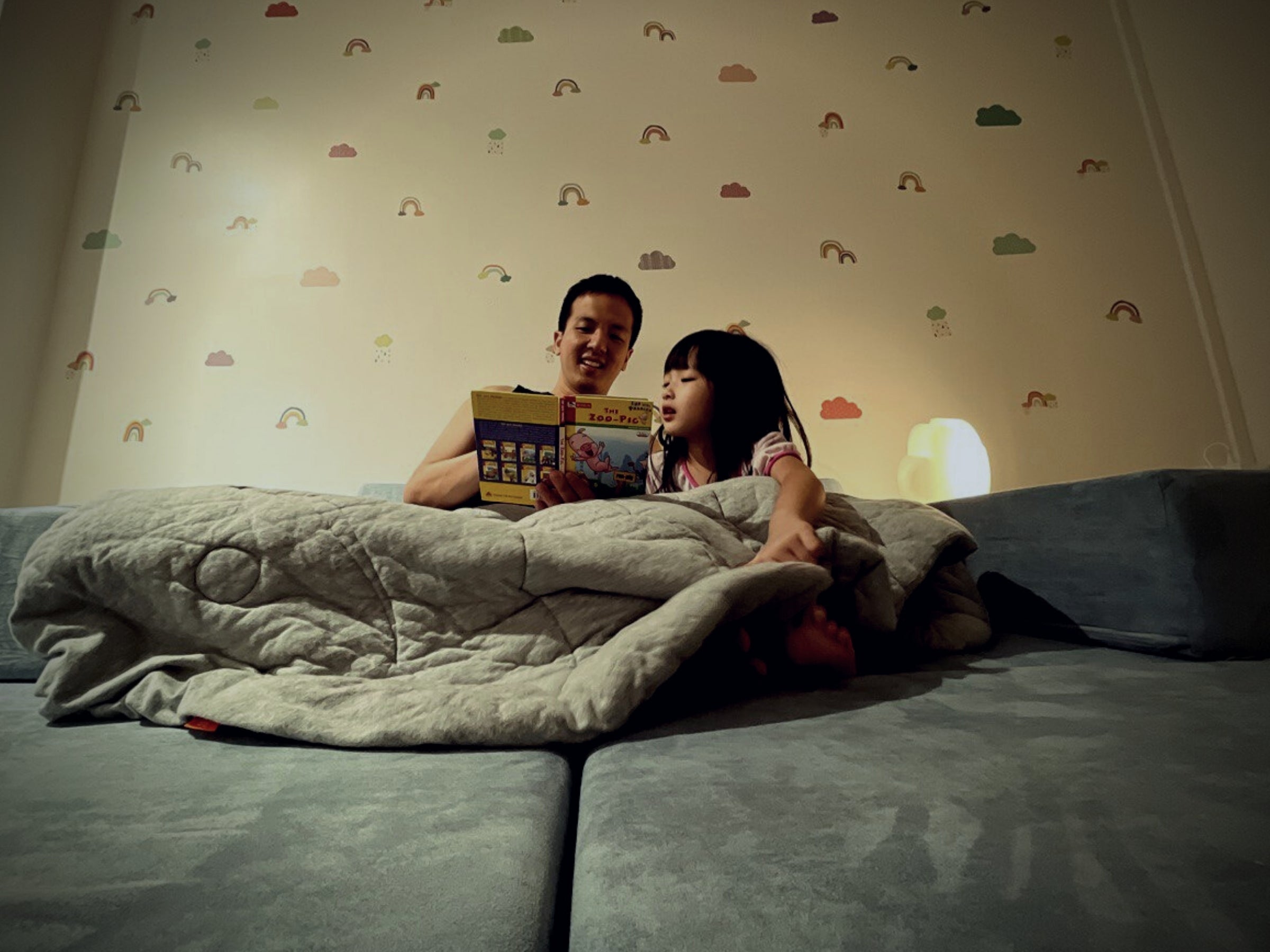 a father and daughter reading bedtime stories on a bed made from Playand modular foam blocks
