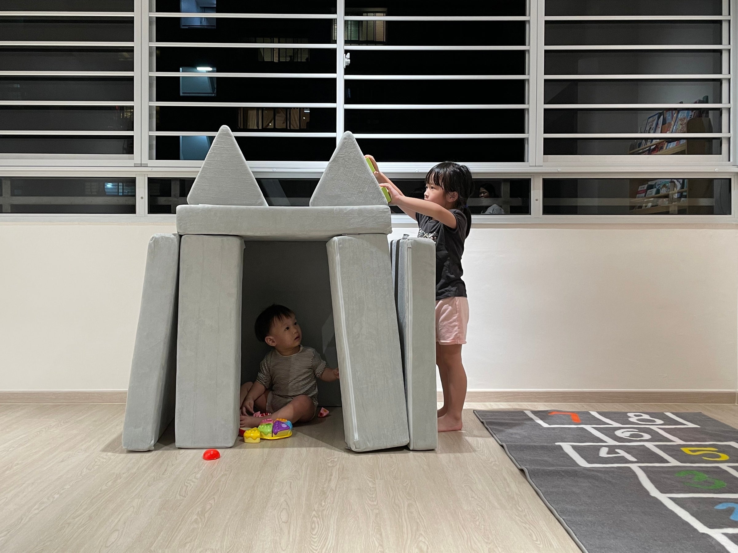 children playing with a playhouse made with Playand modular foam blocks